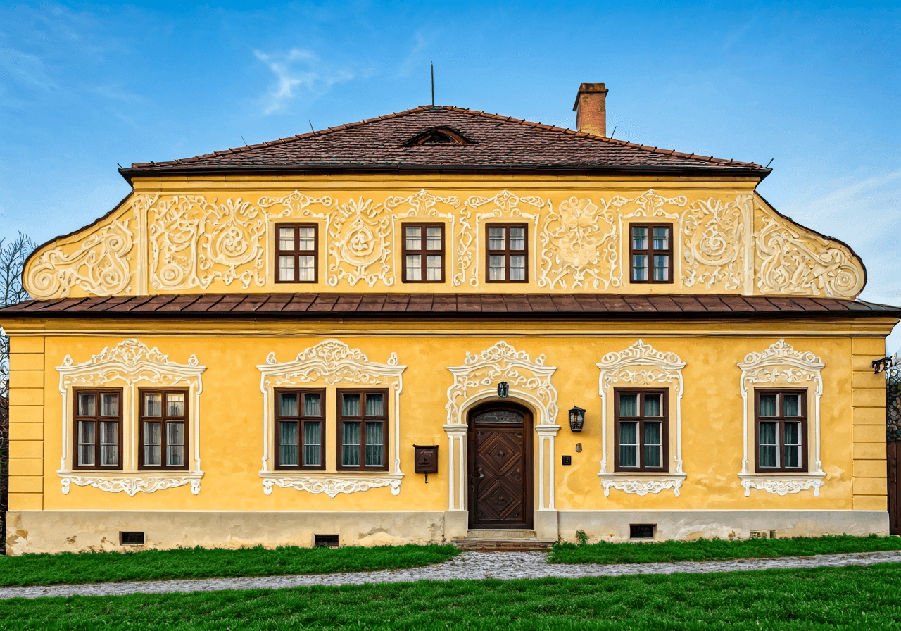 Traditional rural farmhouse in Southern Bohemia showcasing ornate folk baroque facade details, soft morning sunlight, editorial photography style, 85mm lens, high quality, no text, no words, no letters
