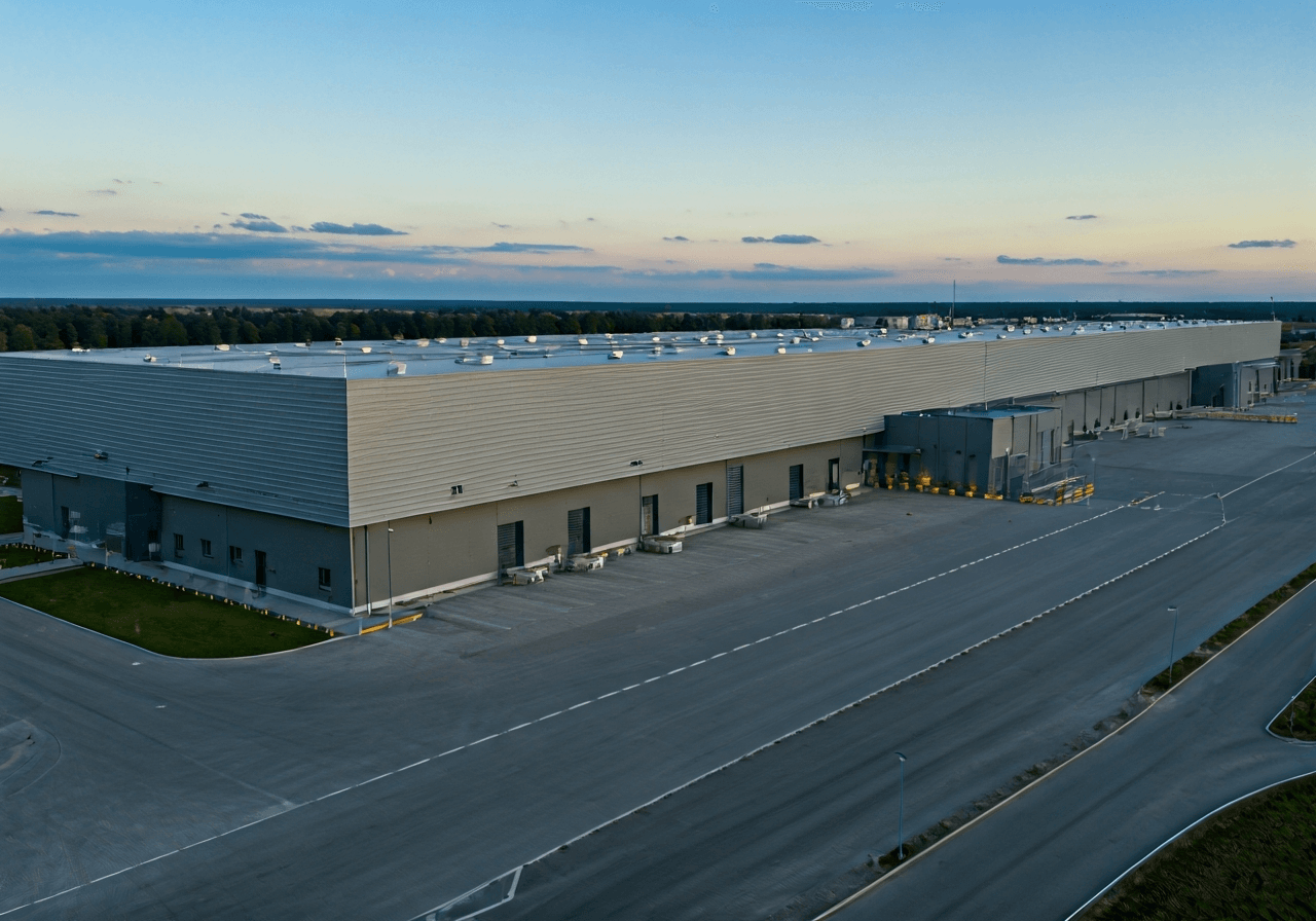 Aerial view of a modern logistics center in Jihlava, industrial architecture, high-tech sorting facility, clean environment, editorial photography, soft daylight, 85mm lens, highly detailed, no text, no words, no letters