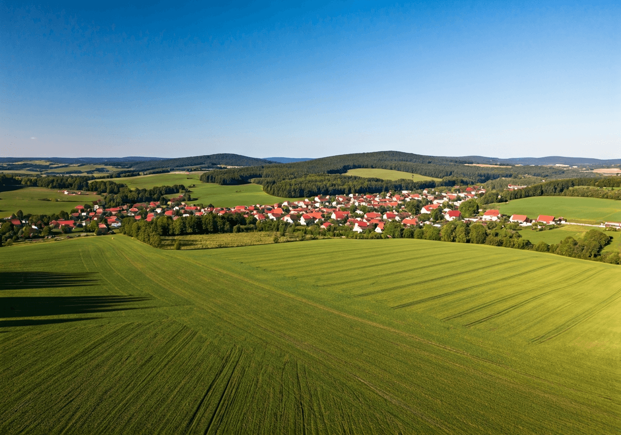 Aerial wide-angle view of the picturesque village Dolní Dobrouč nestled in the rolling green hills of the Pardubice Region, rural Czech Republic, serene atmosphere, editorial photography, natural daylight, high resolution, no text, no letters