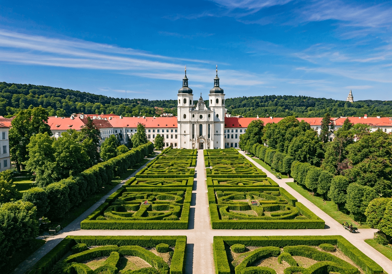 Aerial view of the historical Břevnov Monastery surrounded by lush, vibrant monastery gardens in Prague, editorial photography, calm morning atmosphere, soft natural light, 85mm lens, high resolution, no text, no words, no letters