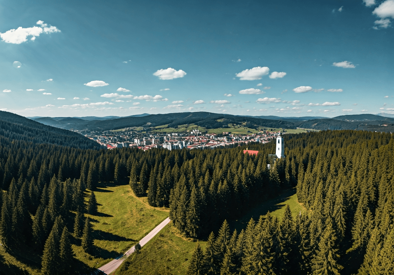 Aerial view of Trutnov city in the foothills of the Krkonoše mountains, lush green environment, clear sky, editorial photography, high contrast, 85mm lens, cinematic lighting, no text, no letters