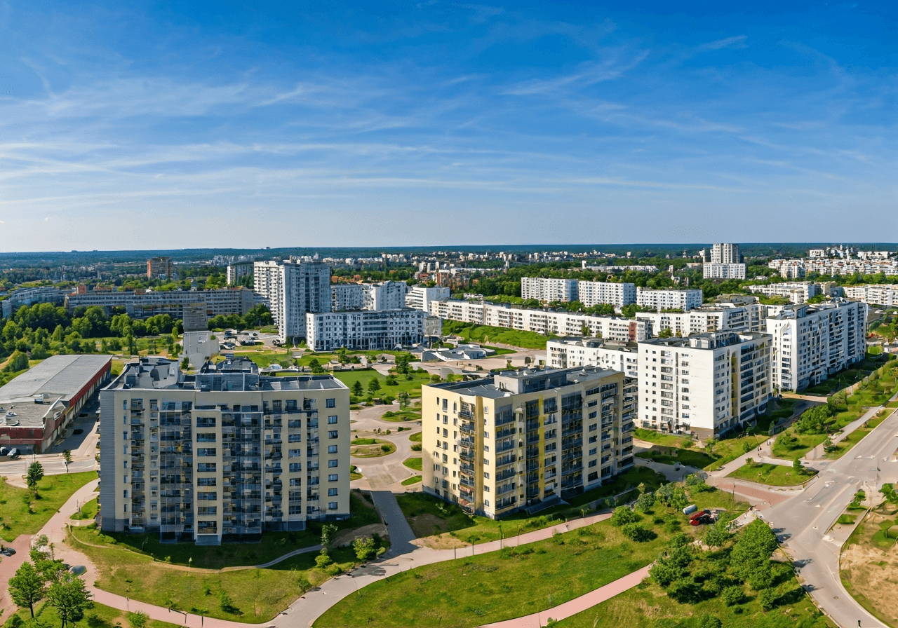 Aerial wide shot of the Hrabůvka residential district in Ostrava, showcasing modern apartment buildings surrounded by greenery, urban layout, sunny day, editorial photography, soft natural light, 85mm lens, high resolution, no text, no letters