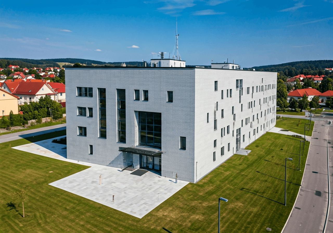 Aerial view of a modern municipal office building in a peaceful Moravian village, clean architectural lines, soft natural morning light, editorial photography style, 85mm lens, high resolution, no text, no words, no letters