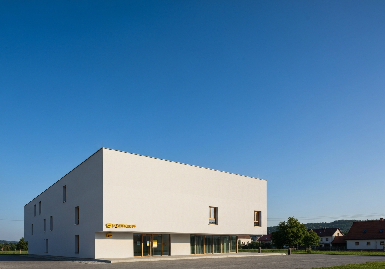 Exterior view of a modern Czech post office building in a rural square, clear blue sky, minimalist architecture, editorial photography, soft natural light, 85mm lens, high resolution, no text, no words, no letters